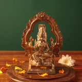 Maariamman idol in front view with floral arch prabhavali seated on a lotus base with white flowers and scattered petals on a wooden plate.