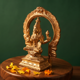 Lakshmi idol on the right side angle with circular arch, Prabhavali seated on a lotus base with yellow and orange petals on a wooden plate.