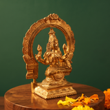 Lakshmi idol on the left side angle with circular arch, Prabhavali seated on a lotus base with yellow and orange petals on a wooden plate.