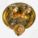 Aarti plate with two bowls and a floral diya shown in closer top-down view with circular engraved design against white backdrop.