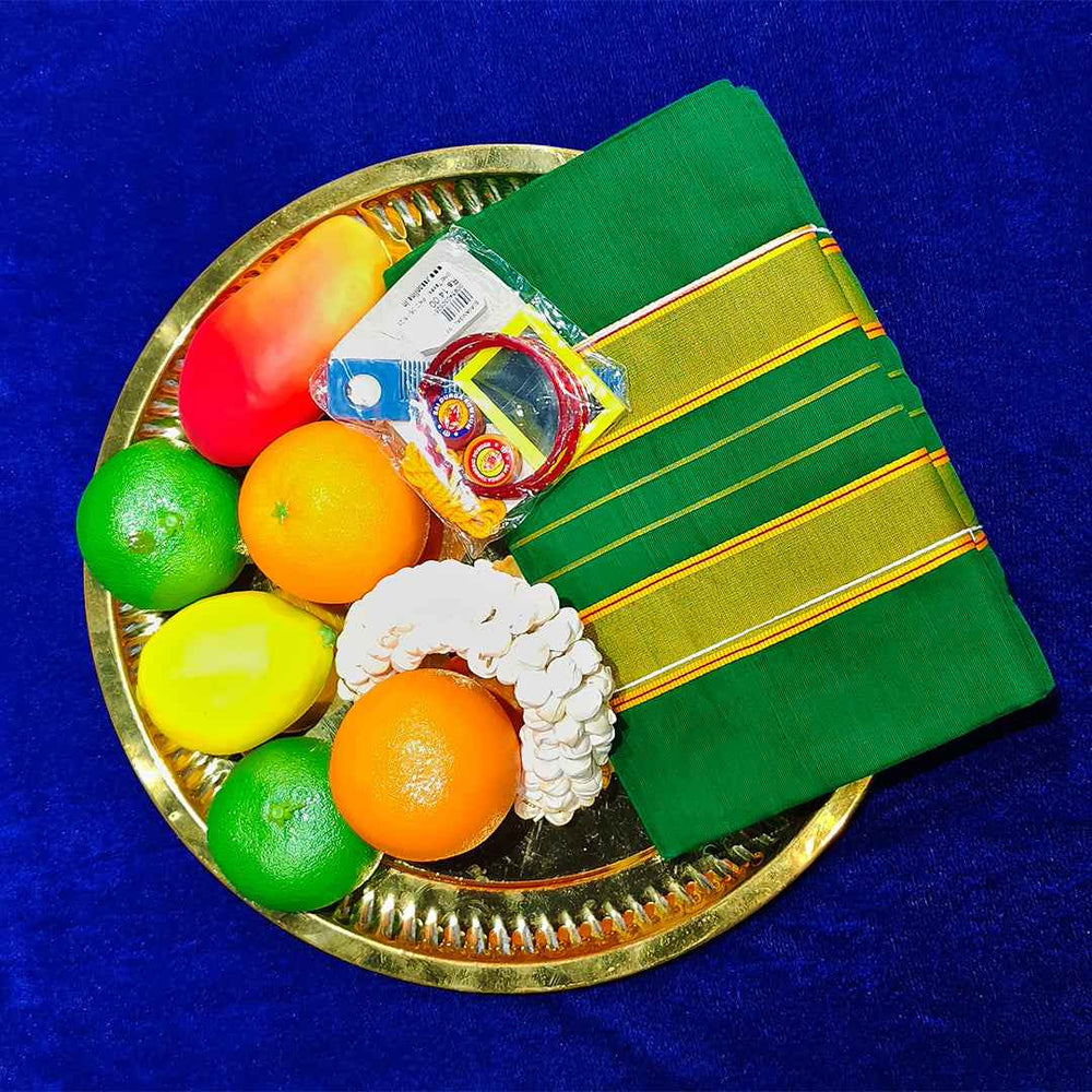 Top view of green amman saree 9 gajan in a gold plate with fruits and flower garland on blue surface
