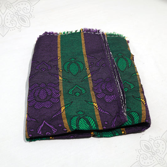 Bedsheet Nelson folded in purple and green floral jacquard pattern with gold stripes on white surface, slight top-down angle view