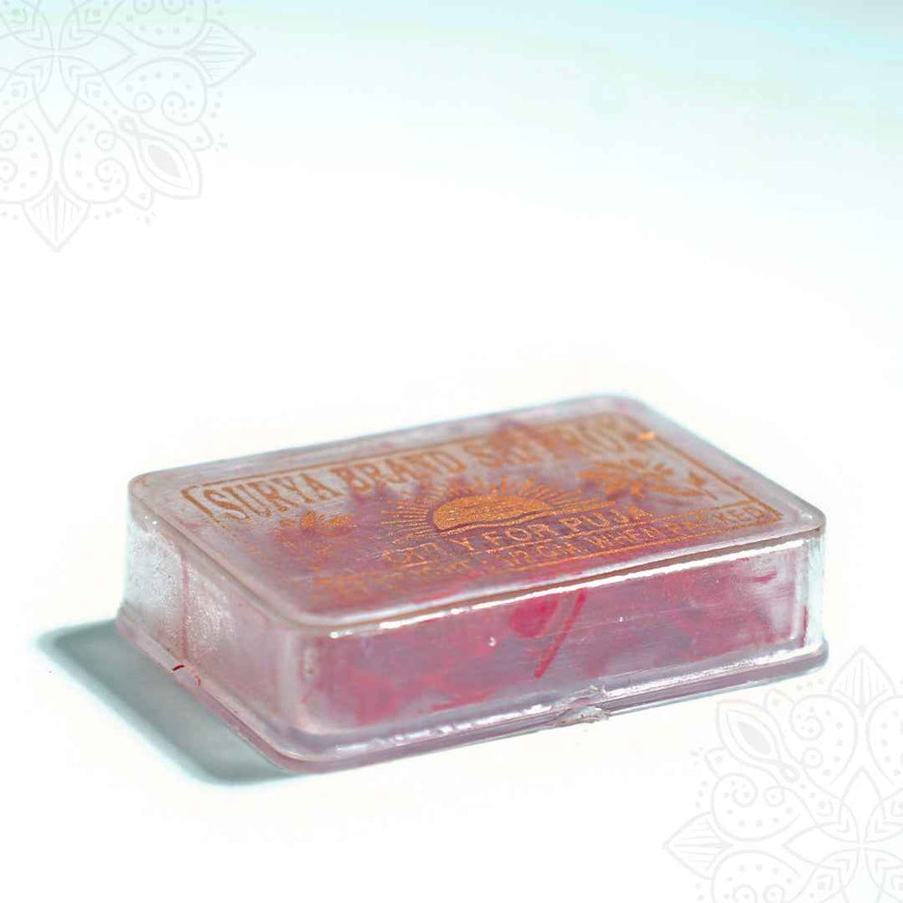 Surya brand saffron puja clear box in a low angle side view showing the box thickness and red saffron strands visible through the sides