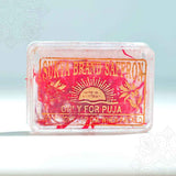 Surya brand saffron puja pack in a front-facing view showing clear box with gold printed label and red saffron strands inside