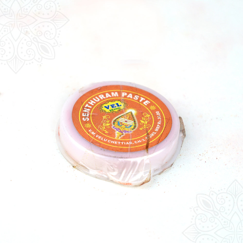 Vel senthuram paste tin top angled view showing sacred red tilak paste container closely with label