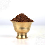 Thirtha parimalam powder heaped in a ridged puja bowl shown in straight front view against white backdrop.