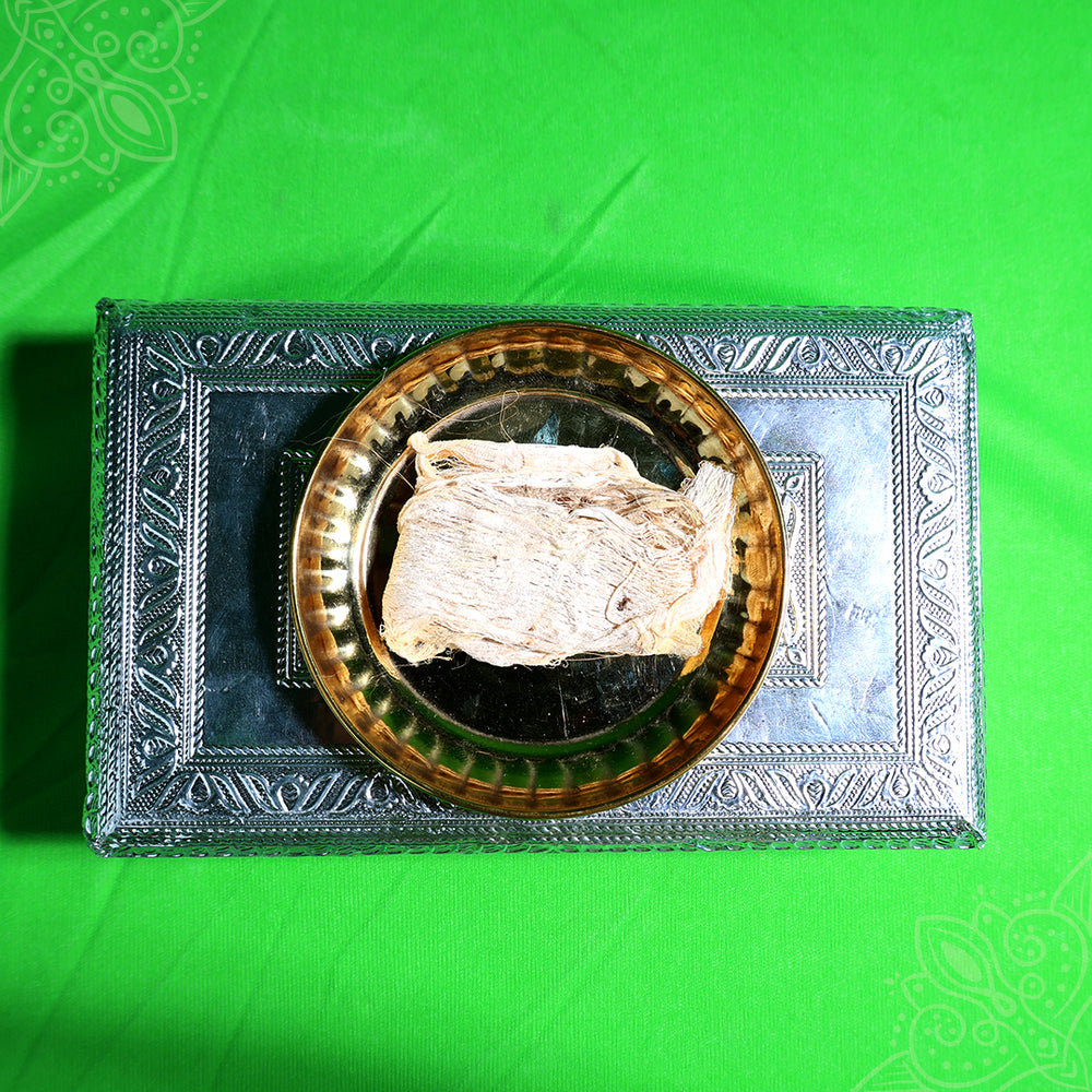 Vazhai thandu thiri wick folded piece placed in metal urli plate top view for daily pooja