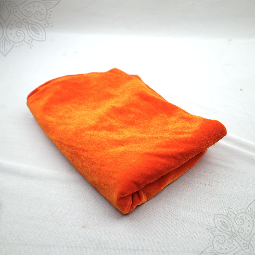 Orange velvet cloth 1 meter folded neatly on white background top angle view for pooja decoration