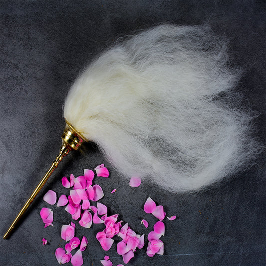 Vensamaram small fan with white hair tuft and metal handle placed angled view with rose petals on dark background
