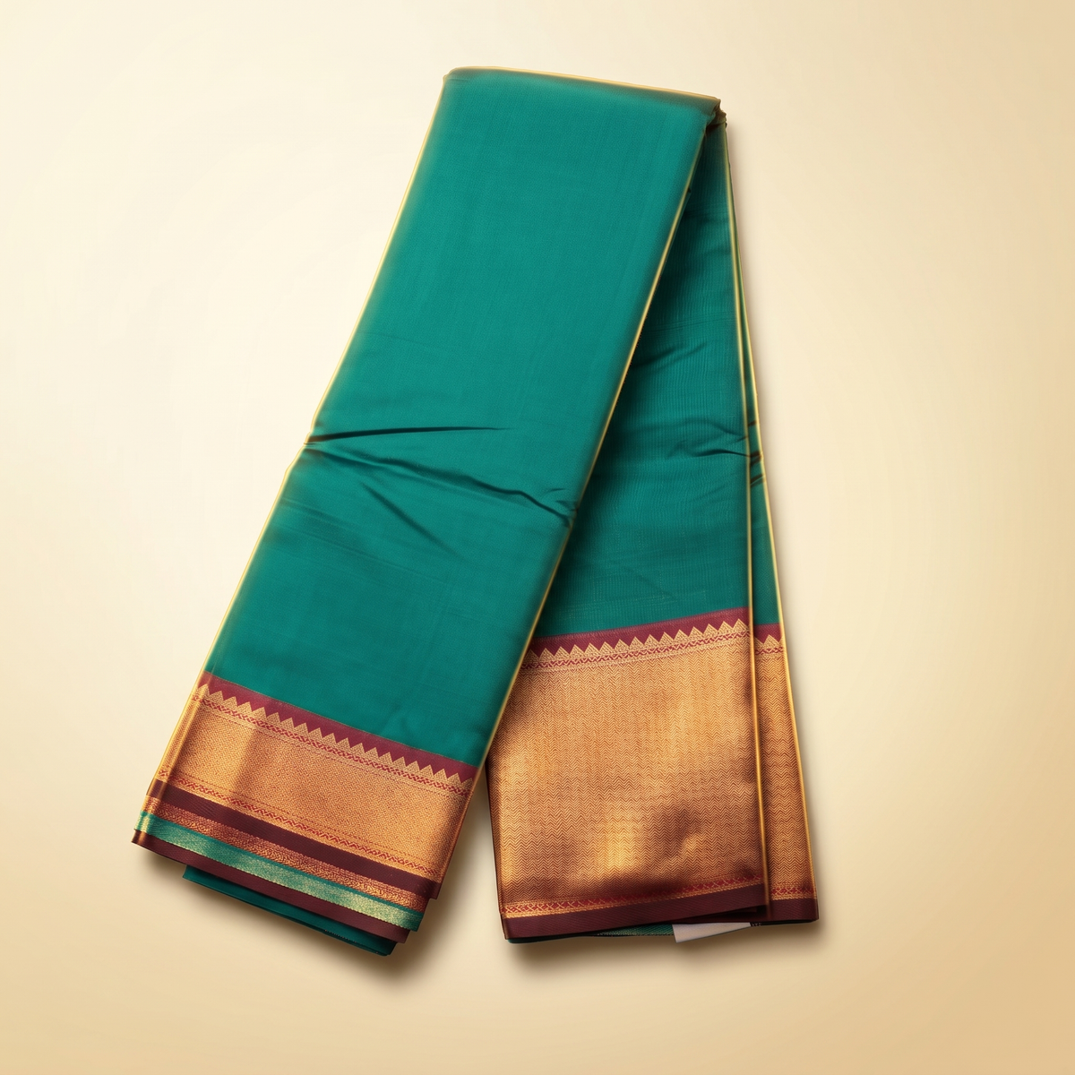 Amman soft silk saree 7 inch border in teal green with golden zari border pallu, draped straight front view.