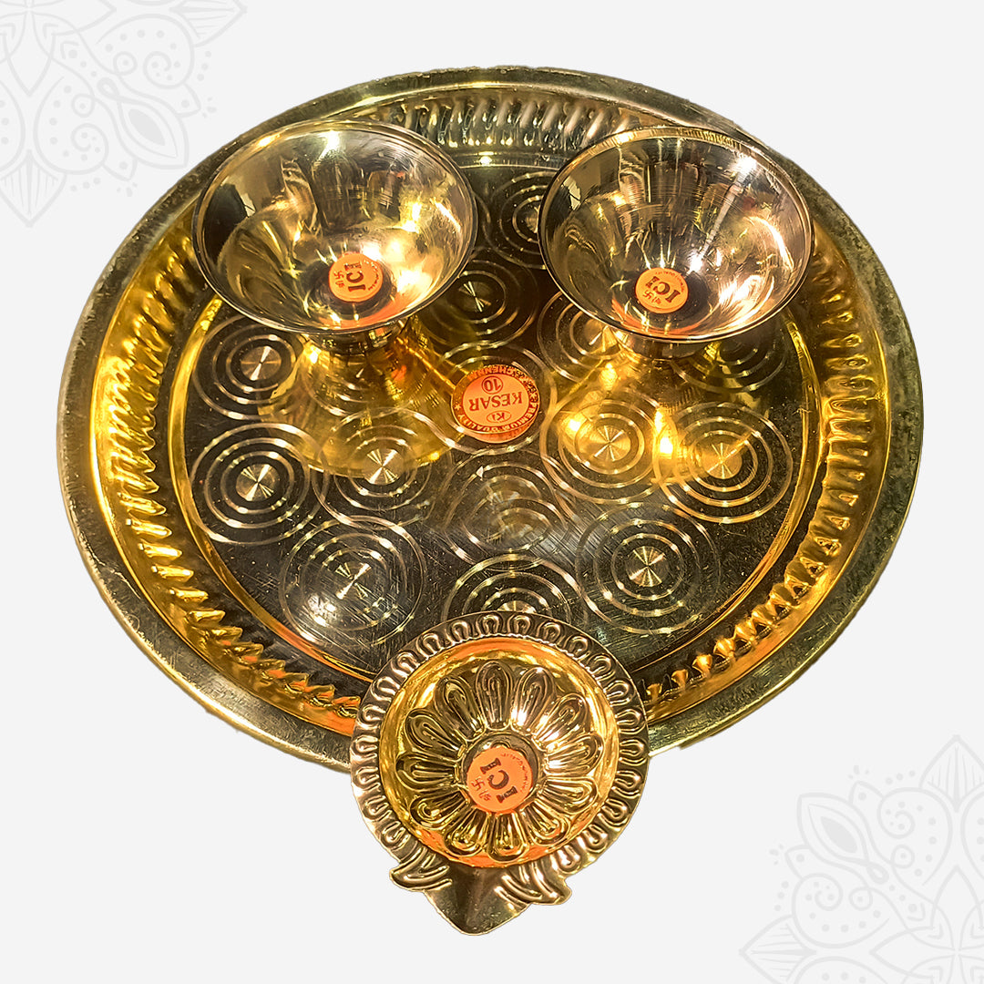 Aarti plate with two bowls and a floral diya shown in closer top-down view with circular engraved design against white backdrop.