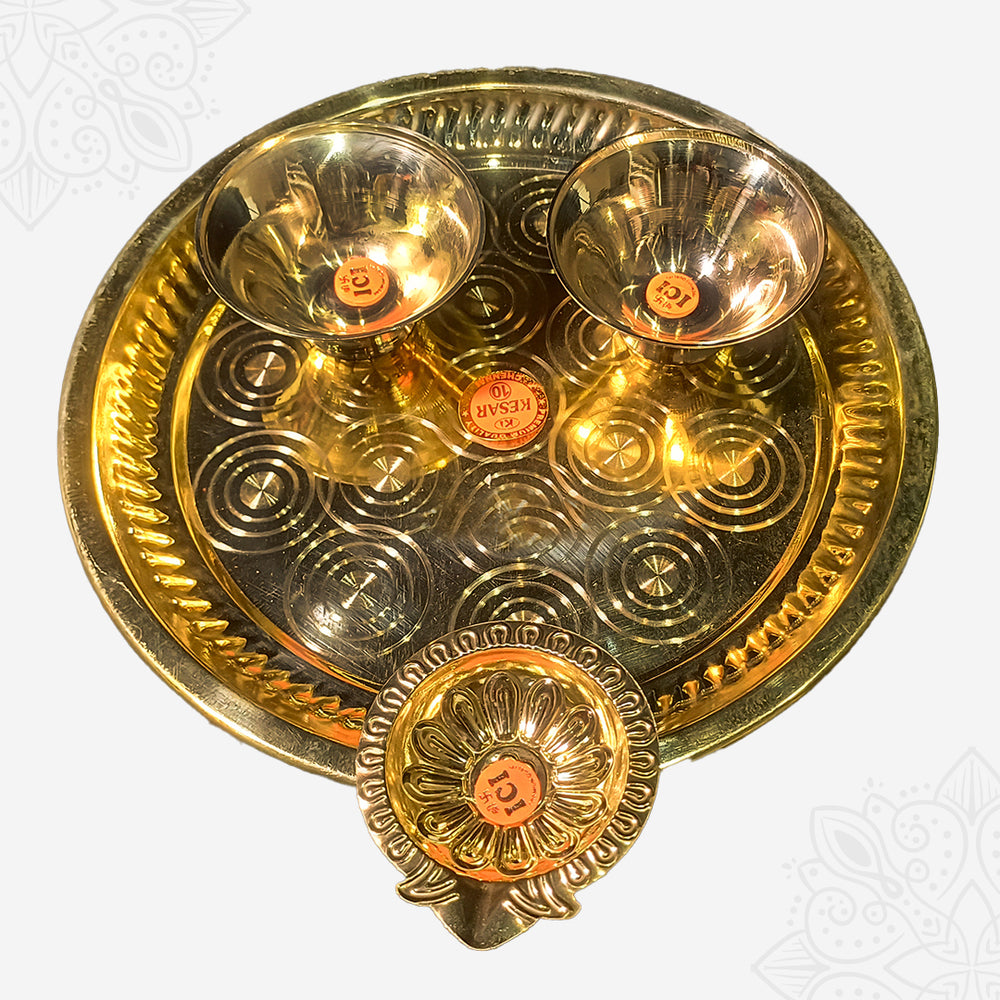 Aarti plate with two bowls and a floral diya shown in closer top-down view with circular engraved design against white backdrop.