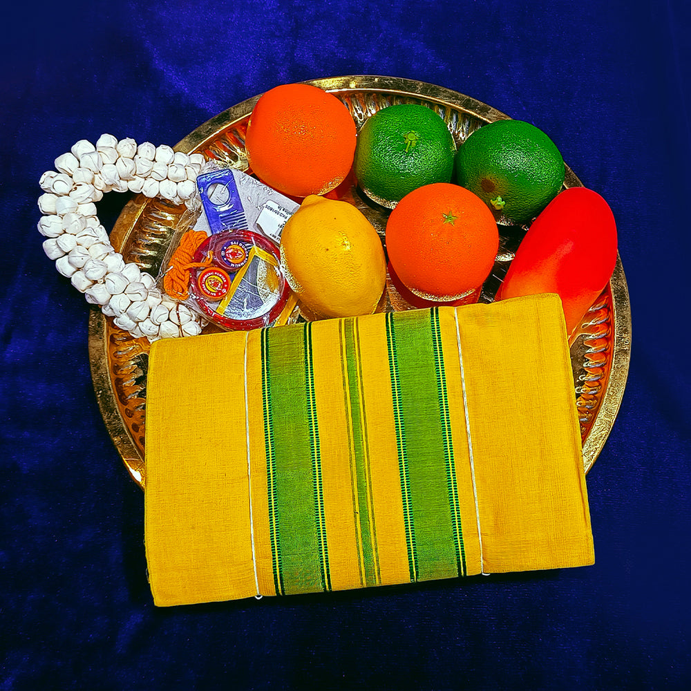 Top view of yellow green amman saree 6 gajan in a gold plate with fruits and flower garland on blue surface
