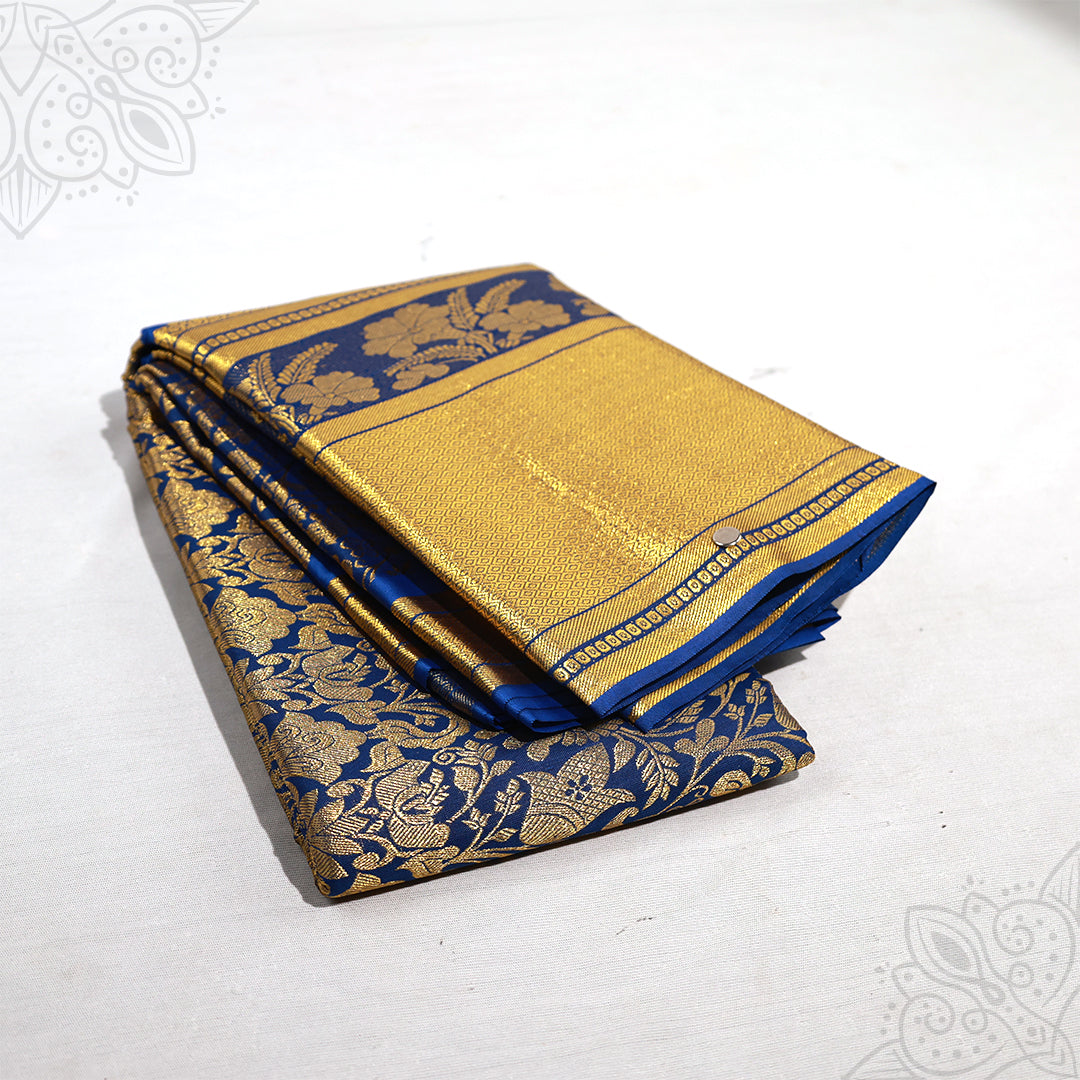 Blue amman saree with big gold jacquard floral design folded neatly side angle view for pooja and special occasions