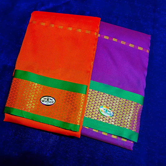 Two folded Amman sarees in Red and Violet with green and gold zari border placed flat on a blue velvet surface.