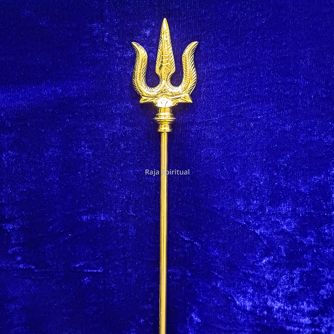 Brass muppattai sulam trishul 2.75ft with engraved trident head shown in straight upright closer front view against blue velvet backdrop.