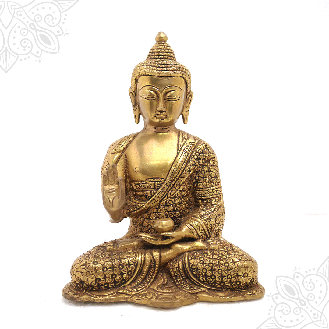 Buddha idol sitting cross legged with blessing hand in straight front view on carved base