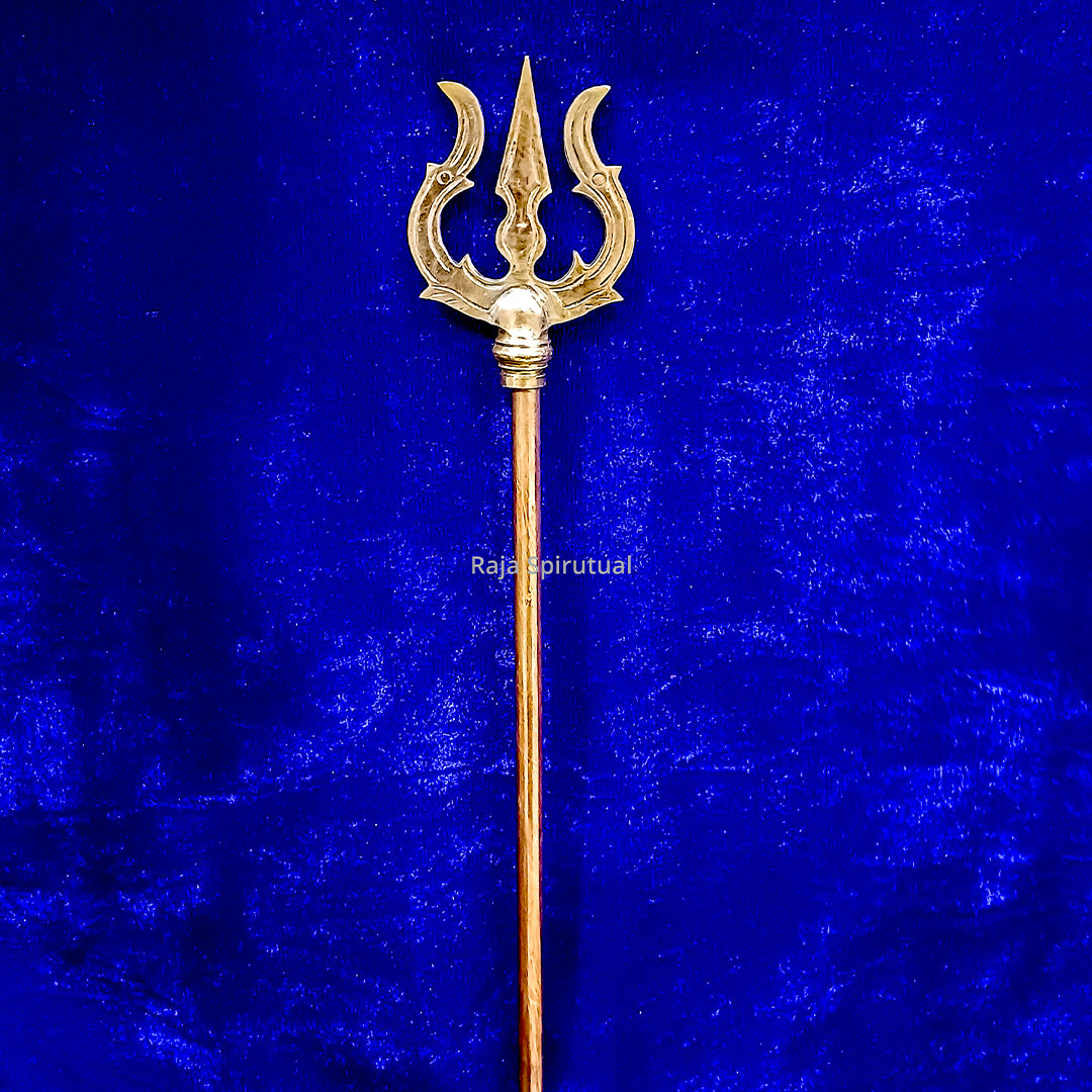 Copper pattai sulam trishul with sharp central prong and decorative head close-up on blue velvet background, straight front view