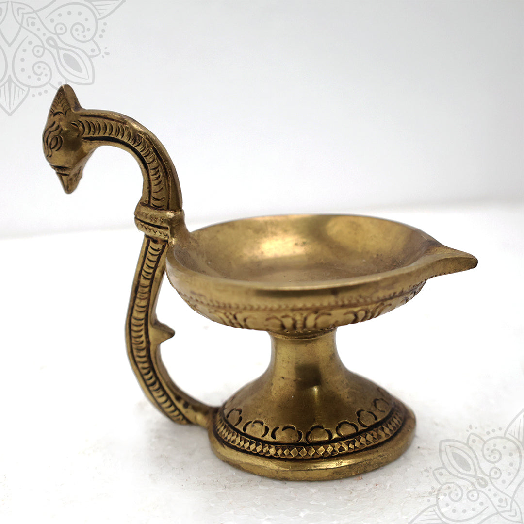 Fancy cup vilaku with peacock handle in a slight right side angle view on a white background
