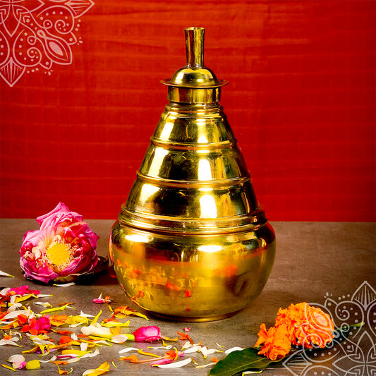 Kumba aarti plain big single piece with smooth tiered top, lotus flower beside, straight front view on orange backdrop