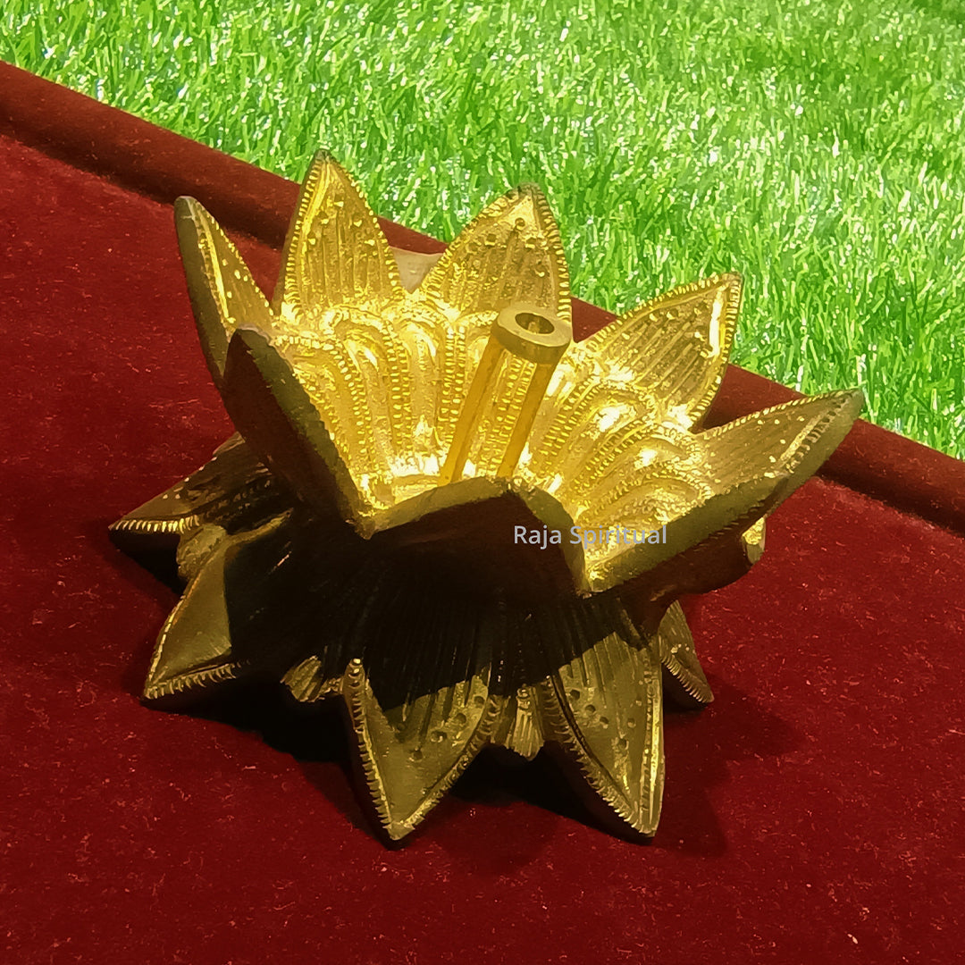 Weight lotus vilaku top right diagonal view with thick engraved pointed petals and wick hole on red velvet green surface
