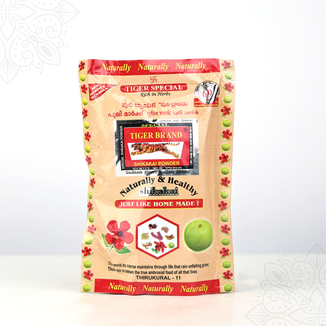 Front view of Tiger Brand special shikakai powder pack with herb and fruit prints on cream pouch against white background
