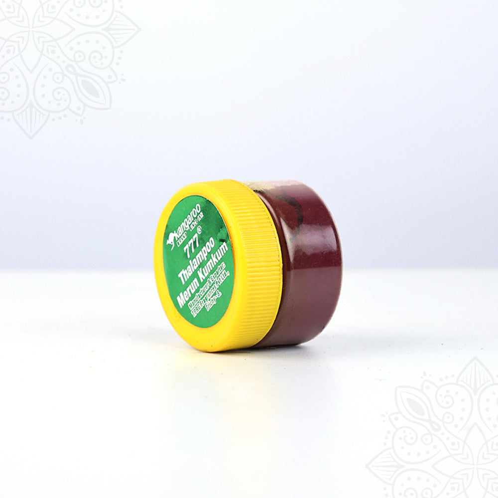 Thazhampoo kumkum box jar lying on side angle view showing yellow lid label for pooja and tilak rituals
