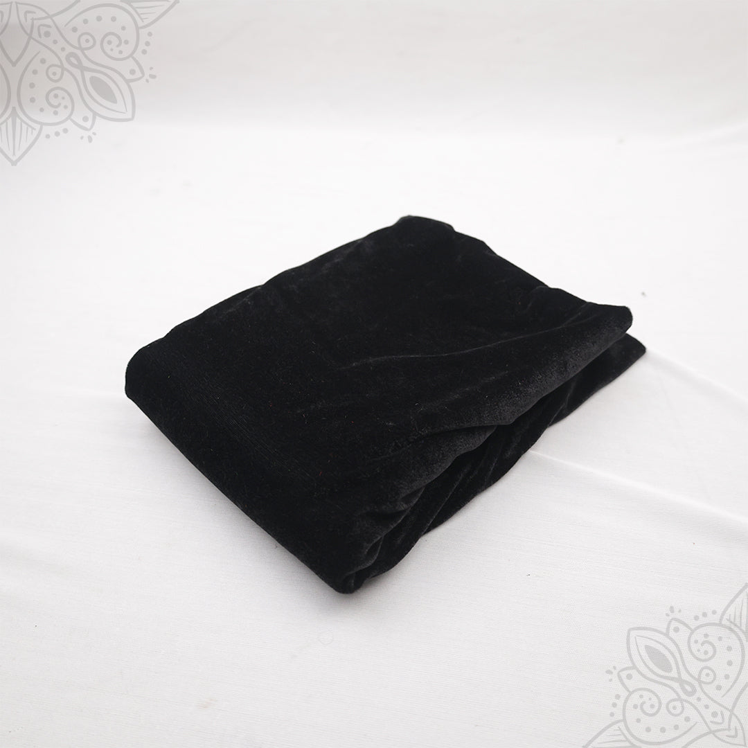 Black velvet cloth 1 meter folded neatly on white background top angle view for pooja decoration