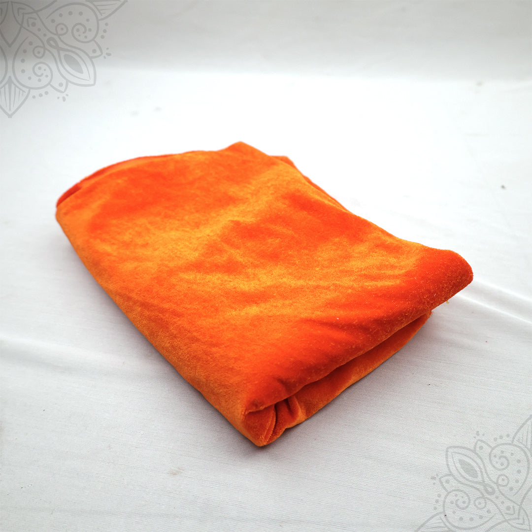Orange velvet cloth 1 meter folded neatly on white background top angle view for pooja decoration