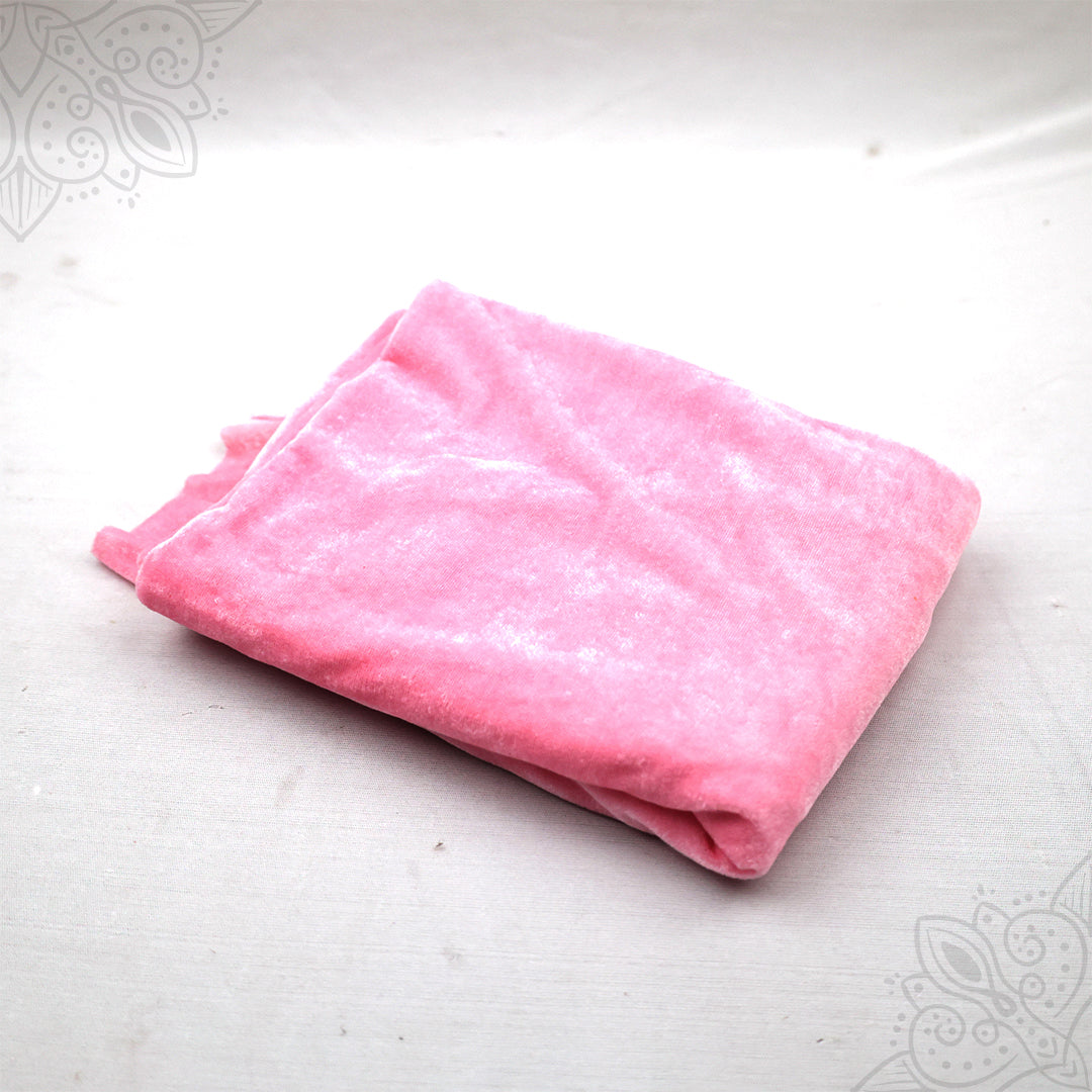 Pink velvet cloth 1 meter folded neatly on white background top angle view for pooja decoration