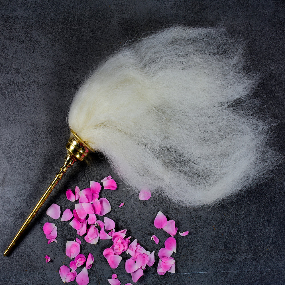 Vensamaram weight whisk with white hair and metal handle top angle view kept with pink rose petals on dark surface