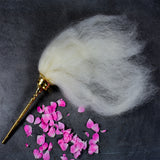 Vensamaram weight whisk with white hair and metal handle top angle view kept with pink rose petals on dark surface